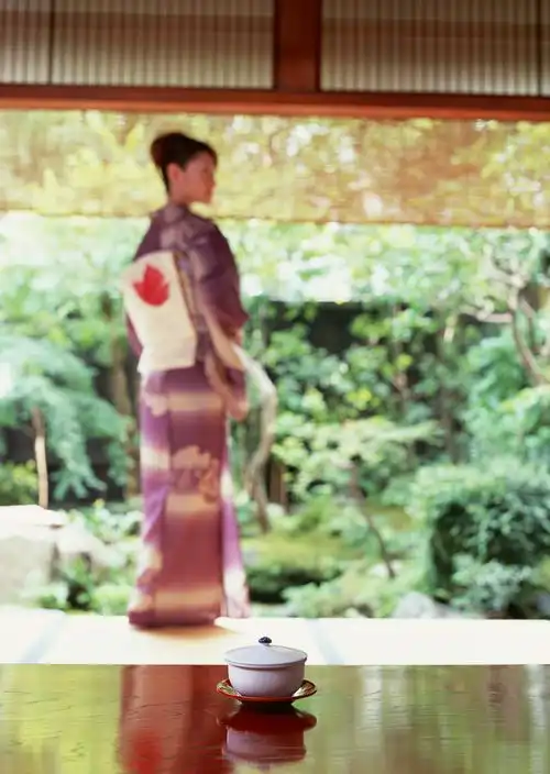 站在放着茶杯的桌子前的和服女子涛涛江水